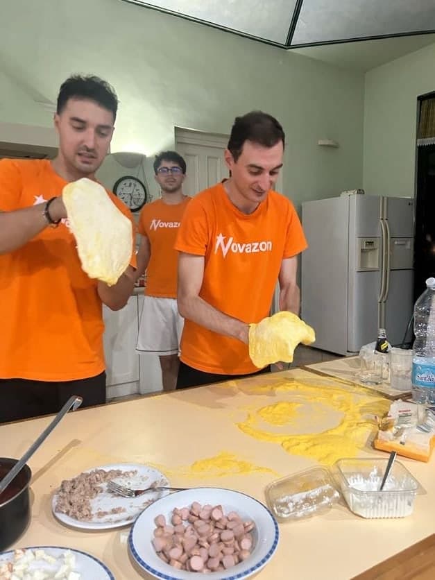 Two team members kneading dough in the kitchen, in Novazon t-shirts